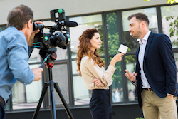 Journalist and cameraman interviewing a person